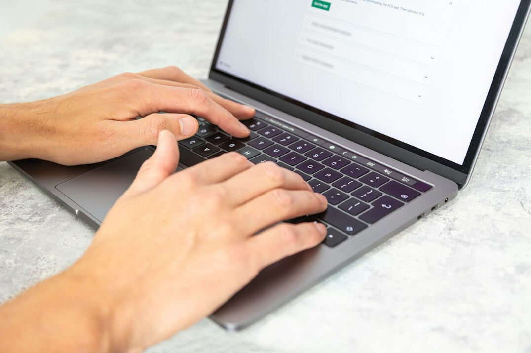 person typing code on laptop
