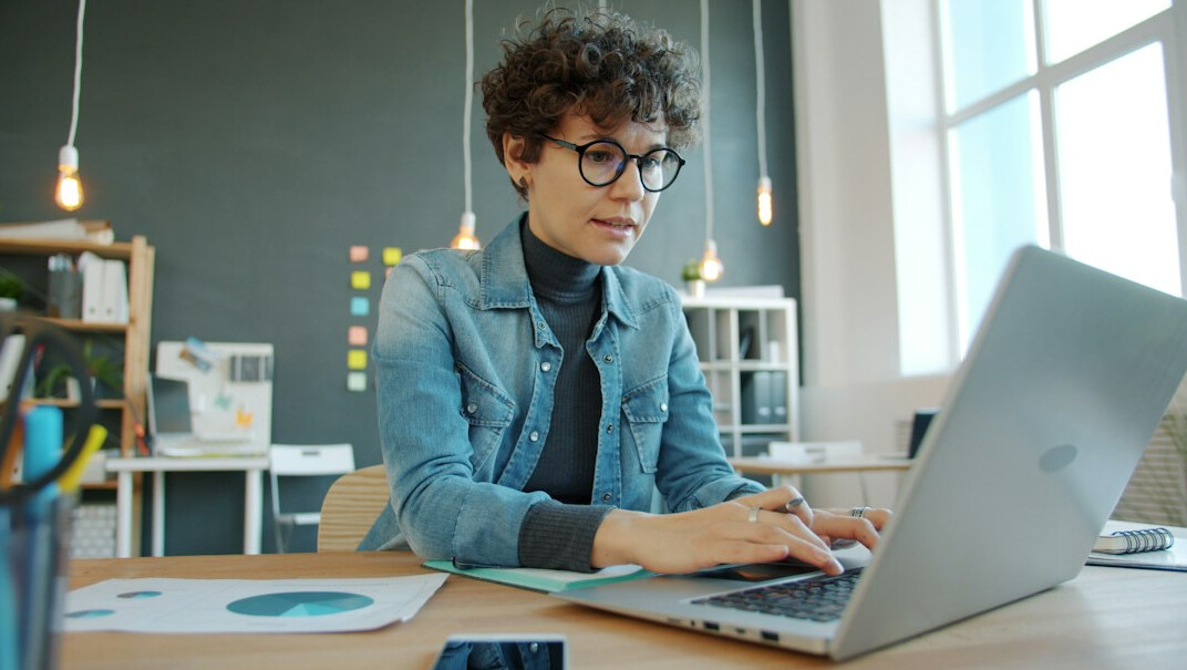 person coding on laptop in office